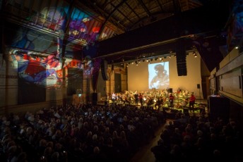 Photos and images adorn the screen and the ceiling